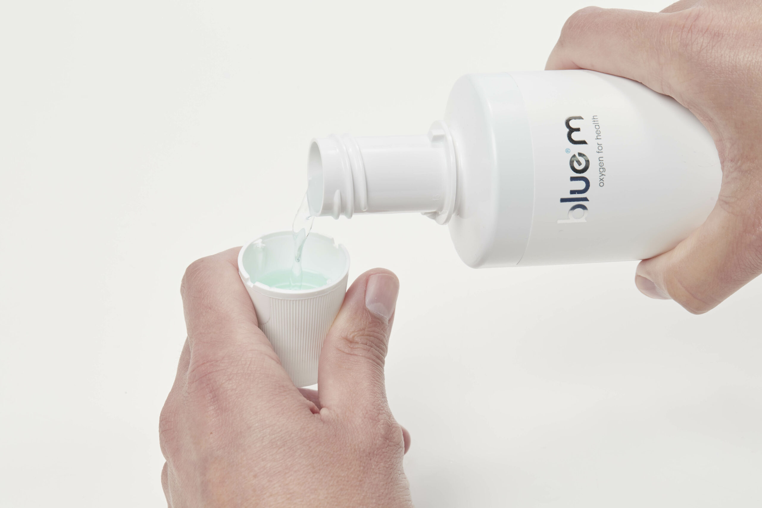 hand pours mouthwash in cap